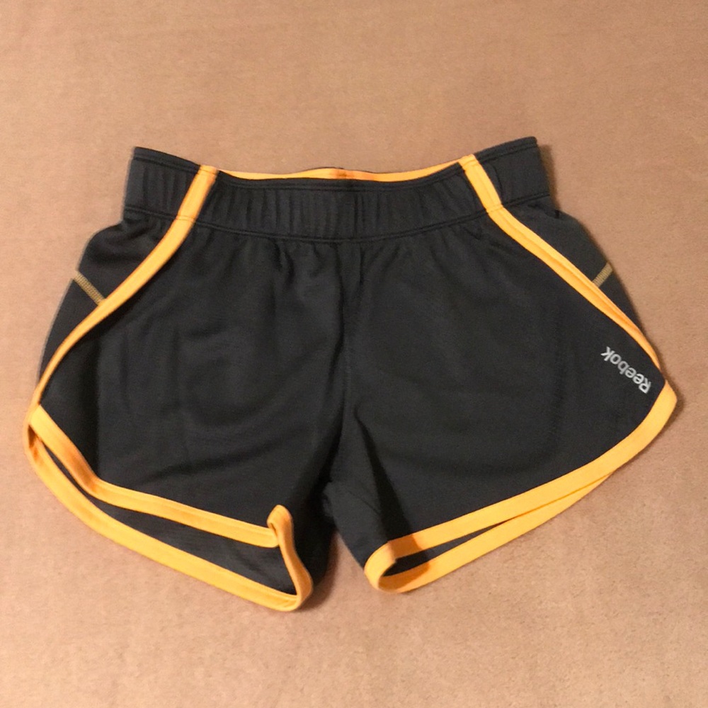 NWOT Reebok Speedwick athletic dolphin hem shorts. Orange and gray. Size XS.